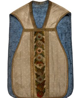 Zdjęcie nr 1: Boki ornatu z białej tkaniny wiskozowej, żakardowej. Wzór o kompozycji rzędowej z motywem trzech nachodzących na siebie okręgów, zwróconych w prawo lub w lewo i przesuniętymi o połowę szerokości raportu w kolejnych rzędach.
Tylna preteksta z tkaniny półjedwabnej o splocie atłasowym, lansowanej nićmi o oplocie metalowym gładkim i karbowanym oraz nićmi bawełnianymi o splocie rządkowym, całość zabezpieczona ściegiem łańcuszkowym. Kompozycja złożona z dwóch przeplatających się wici; złota ze stylizowanymi strzępiastymi liśćmi i wolutowo wygiętymi witkami, żółto-zielona z liśćmi i owocami winnego krzewu. Na przecięciu ramion krzyża preteksty medalion z wizerunkiem Matki Boskiej Apokaliptycznej. Przednia preteksta haftowana na kanwie ściegiem liczonym nićmi bawełnianymi i wełną; na białym tle główki kwiatów w otoczeniu strzępiastych liści, ułożone wertykalnie, w zimnych odcieniach zieleni, brązu i szarości. 
Galony tkane z nićmi o oplocie miedzianym w wątku, w dwóch szerokościach, z motywem zygzaka, jeden lub dwa brzegi ząbkowane.
Podszewka z tkaniny wiskozowej, żakardowej, w kolorze niebieskim. Wzór o kompozycji pasowej z motywem geometrycznym oraz dwóch rodzajów gałązek z kwiatami  i listkami, zwróconymi w prawo lub w lewo i przesuniętymi o połowę szerokości raportu w kolejnych pasach.
