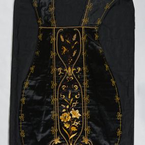Zdjęcie nr 1: Ornat z czarnej tkaniny półjedwabnej o splocie atłasowym.

Preteksty wyznaczone haftem barwnym, ściegiem łańcuszkowym maszynowym nićmi sztucznymi, uzupełnione haftem kładzionym z sutaszem o oplocie miedzianym złoconym oraz haftem na podkładzie tekturowym nićmi gładkimi i karbowanymi o oplocie miedzianym złoconym. Kompozycja roślinno-kwiatowa zamknięta pomiędzy dwoma wiciami fantazyjnie wygiętymi na zakończeniach, z motywami lilii andegaweńskich, w kolorze złotym oraz gałązek winnej latorośli z gronami, kłosami zboża i gałązkami kwiatu róży i lilii, w odcieniach brązu. Na przecięciu ramion tylnej preteksty litery IHS z krzyżem łacińskim i gwoźdźmi, w kolorze złotym. Całość otacza dekoracyjny fryz w kolorze żółtym.

Podszewka z tkaniny bawełnianej o splocie rządkowym, w kolorze czarnym. Na podszewce metka w kolorze białym, z jasnoniebieskim napisem: "Made in France/The C. Wildermann Co/NEW - YORK".
