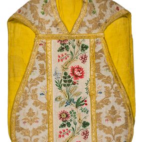 Zdjęcie nr 1: Boki ornatu z tkaniny jedwabnej, o tle atłasowym lansowanej nićmi o oplocie metalowym w kolorze złotym oraz nićmi jedwabnymi wielobarwnymi. Wzór o kompozycji sieciowej, wyznaczony przez faliste, wznoszące się ku górze wici z bujnych liści, wyznaczające pola, w których dwa rodzaje symetrycznych kompozycji z kwiatów, liści i traw.

Preteksty z tafty w kolorze białym, pokrytej ściegiem łańcuszkowym. Wzór o splotach rządkowych, lansowany barwnymi nićmi jedwabnymi i nićmi o oplocie metalowym w kolorze złotym. Wzór z motywem falistej wici roślinnej z polnymi kwiatami, kłosami zbóż oraz kiściami winogron.

Galon tkany z nićmi o oplocie metalowym w wątku, w kolorze złotym, z motywem falistej wici roślinnej z liśćmi.

Podszewka z tkaniny bawełnianej, adamaszkowej, w kolorze żółtym, z motywem zygzaka przeplatającego się z wicią roślinną.