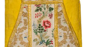 Zdjęcie nr 1: Boki ornatu z tkaniny jedwabnej, o tle atłasowym lansowanej nićmi o oplocie metalowym w kolorze złotym oraz nićmi jedwabnymi wielobarwnymi. Wzór o kompozycji sieciowej, wyznaczony przez faliste, wznoszące się ku górze wici z bujnych liści, wyznaczające pola, w których dwa rodzaje symetrycznych kompozycji z kwiatów, liści i traw.

Preteksty z tafty w kolorze białym, pokrytej ściegiem łańcuszkowym. Wzór o splotach rządkowych, lansowany barwnymi nićmi jedwabnymi i nićmi o oplocie metalowym w kolorze złotym. Wzór z motywem falistej wici roślinnej z polnymi kwiatami, kłosami zbóż oraz kiściami winogron.

Galon tkany z nićmi o oplocie metalowym w wątku, w kolorze złotym, z motywem falistej wici roślinnej z liśćmi.

Podszewka z tkaniny bawełnianej, adamaszkowej, w kolorze żółtym, z motywem zygzaka przeplatającego się z wicią roślinną.