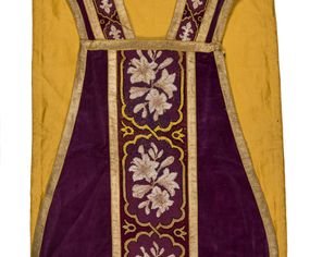 Zdjęcie nr 1: Boki ornatu z gładkiego aksamitu bawełnianego w kolorze fioletowym.

Preteksty z haftem liczonym na kanwie, nićmi bawełnianymi, z motywem dwóch przeplatających się taśm zakreślających medaliony o ozdobnym wykroju, w których polu kwiaty i pąki lilii. Pas wokół wycięcia na głowę z mniejszymi medalionami, w których polu lilie heraldyczne.

Galon tkany z nićmi o oplocie metalowym w kolorze złotym, z motywem ukośnych prążków.

Podszewka z satyny bawełnianej, w kolorze żółtym.